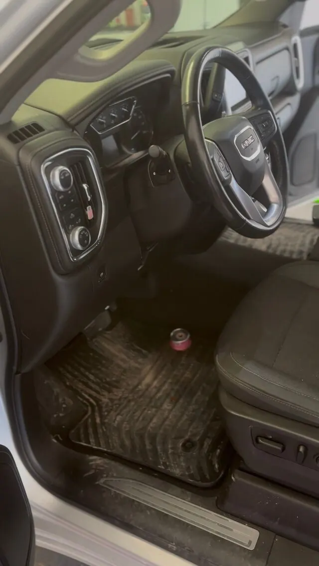 GMC truck cabin before: dirty mats and dusty console