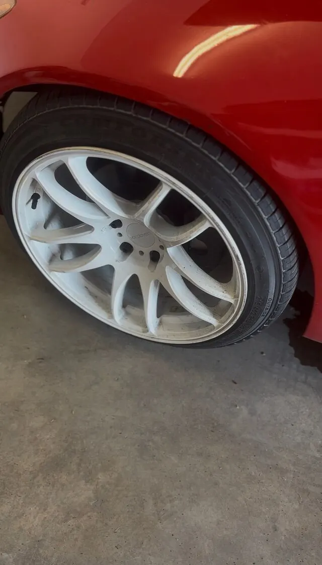 White wheel before: brake dust and a dull tire